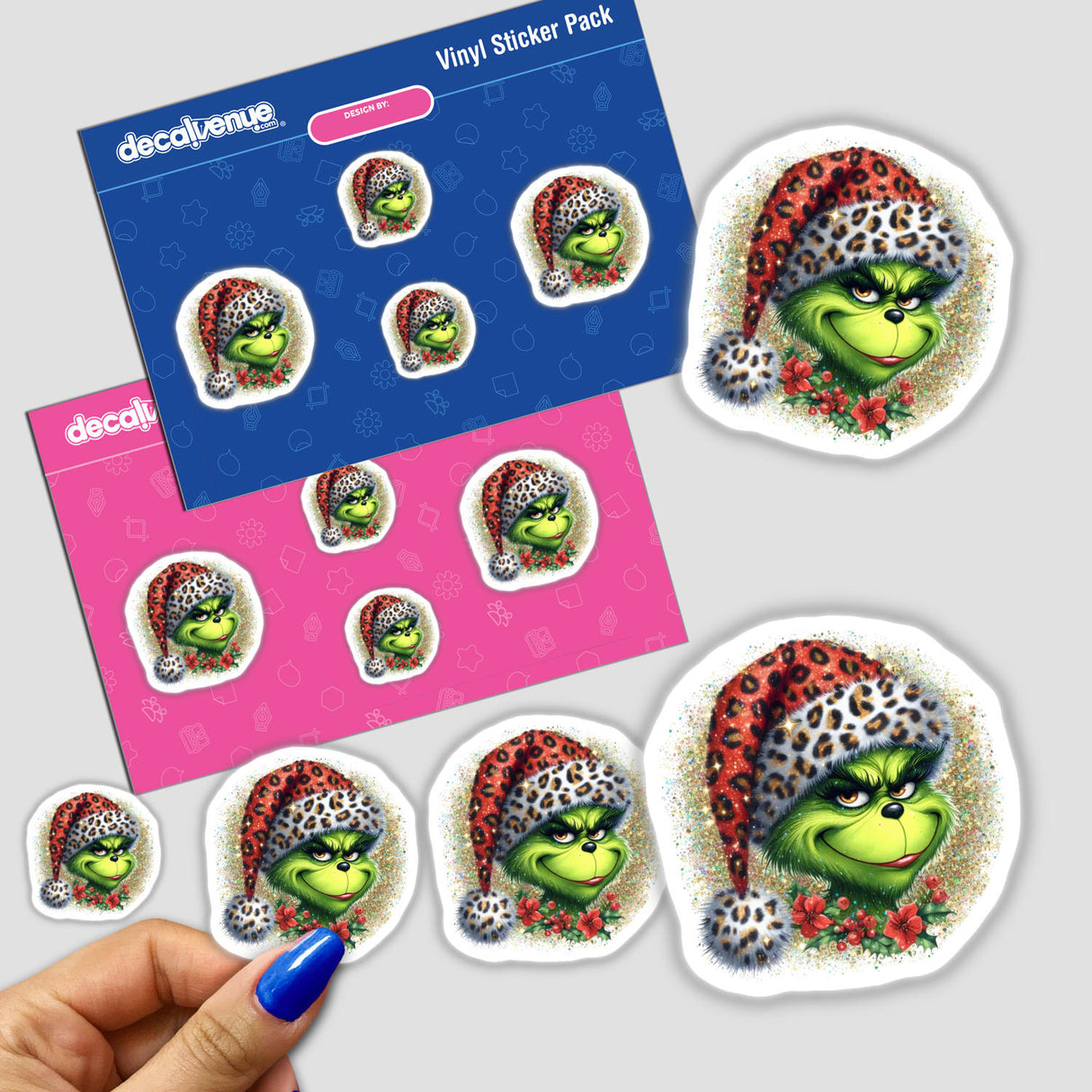 Green Grouch Glitter in Leopard Santa Hat sticker pack, featuring a cartoon character with a green face wearing a festive hat, showcased in a person's hand. Available as stickers or digital artwork.