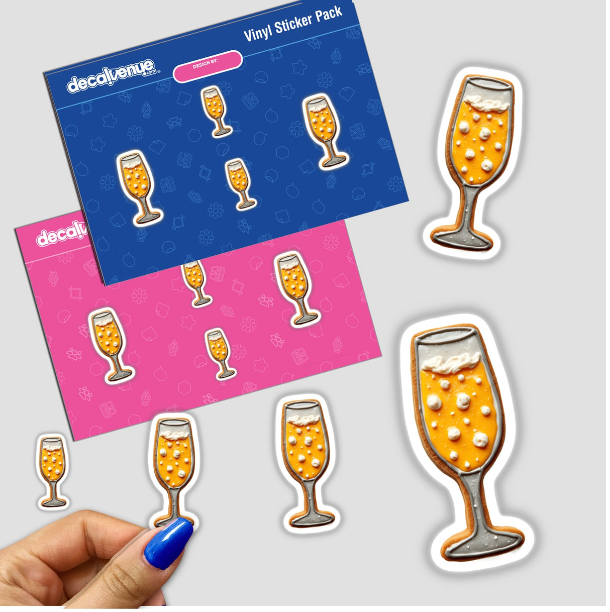 Hand holding a sticker pack featuring a cookie shaped like a champagne glass with bubbly details, perfect for New Year celebrations.