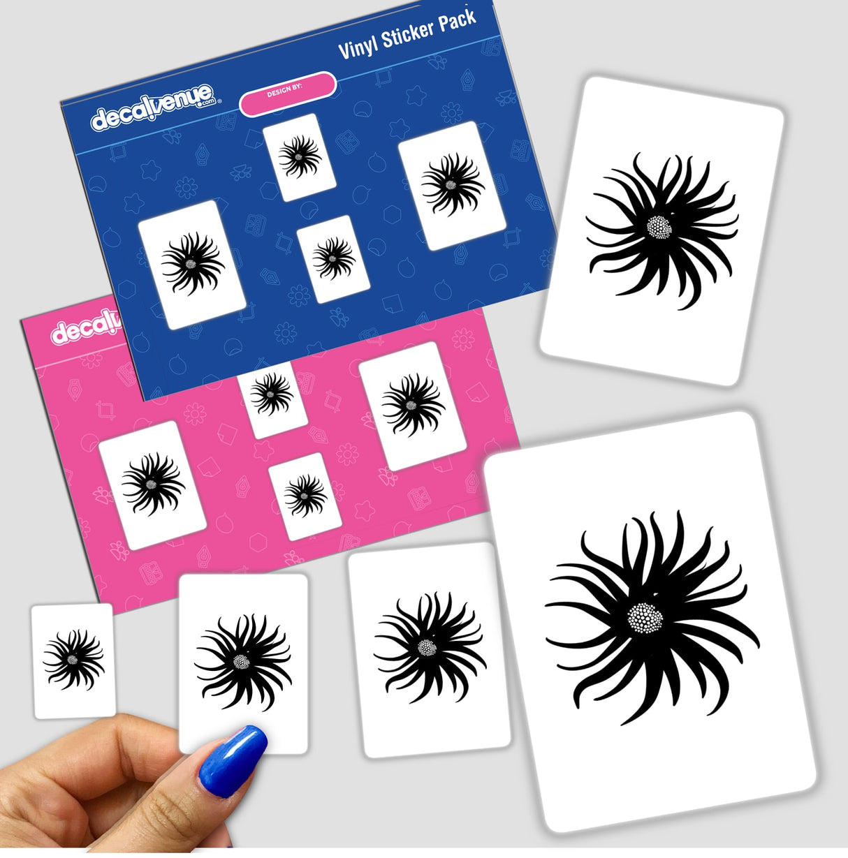 Hand holding a sticker pack featuring an abstract flower design, characterized by intricate black patterns.