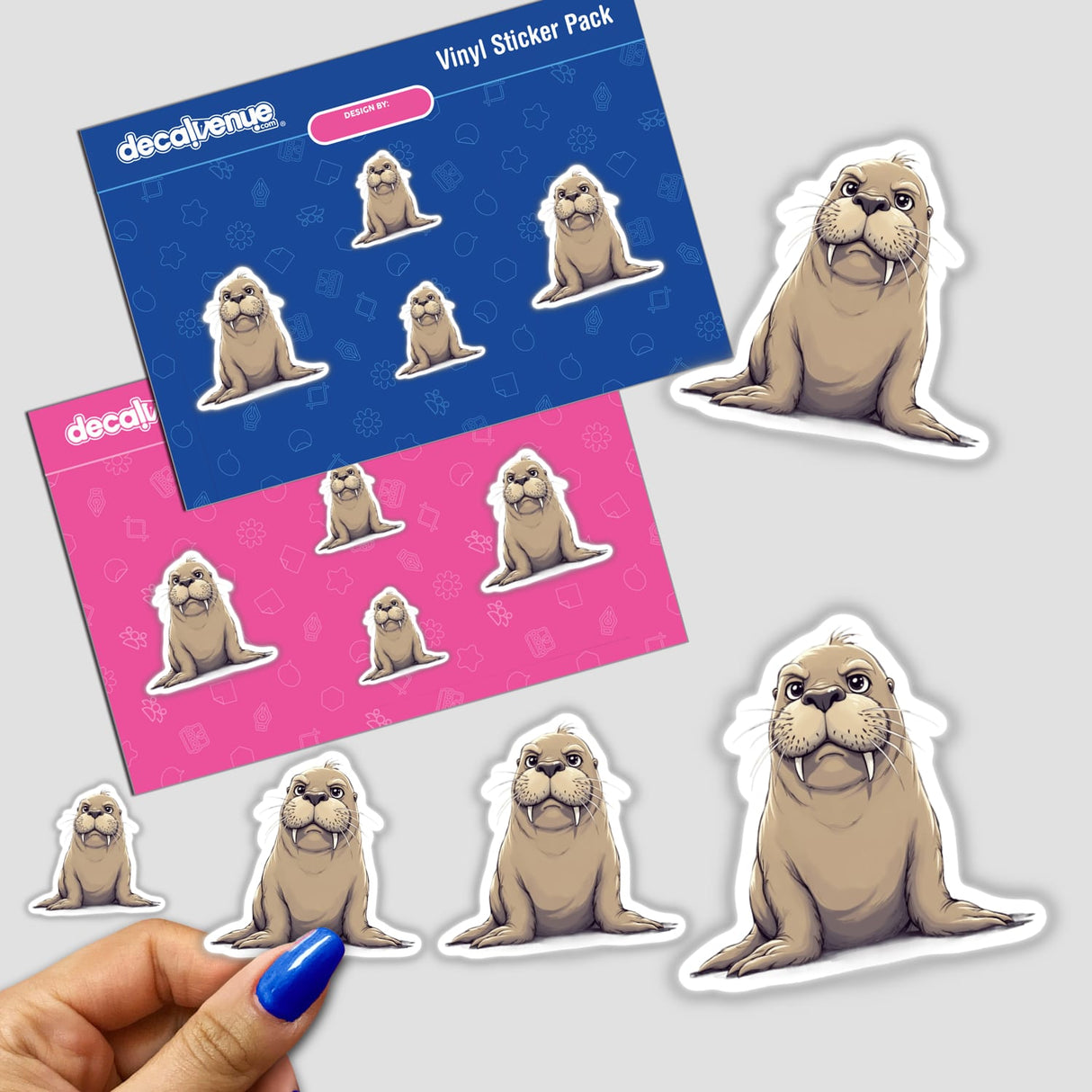 Hand holding a pack of Cute Grumpy Walrus stickers featuring various cartoon walrus illustrations with large teeth and whiskers.