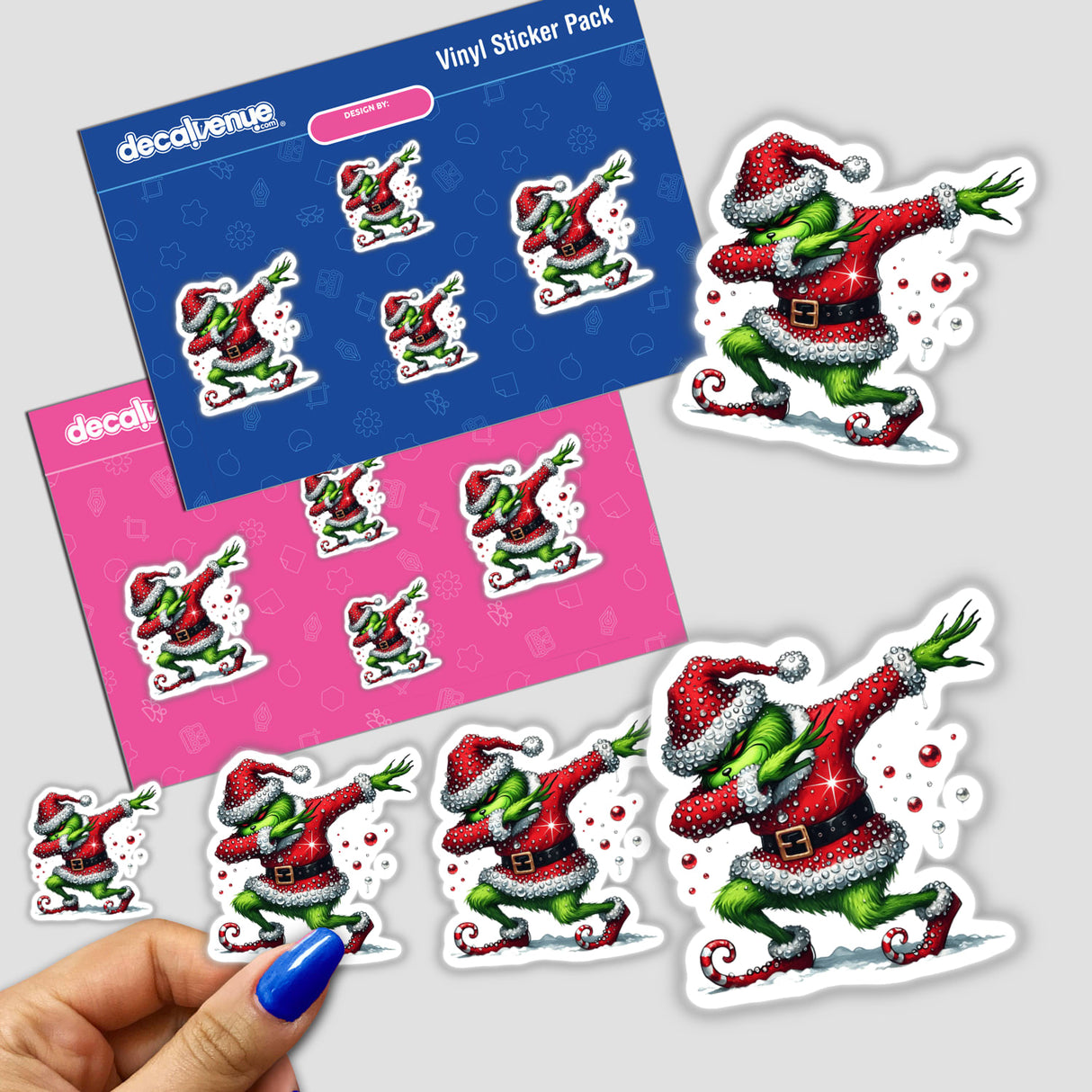 Hand holding a sticker pack featuring the Dabbing Green Grouch in a Santa rhinestone outfit, highlighting unique cartoon character decals from Decal Venue.