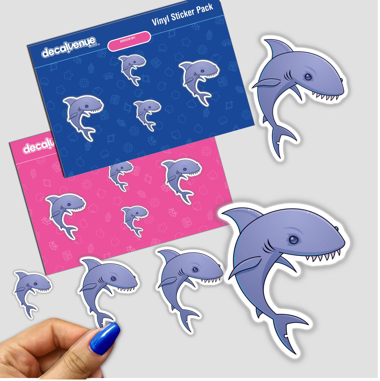 A hand holds the Sharky sticker pack, featuring playful cartoon sharks with sharp teeth, ideal for unique decoration from Decal Venue's collection of distinctive stickers and digital art.