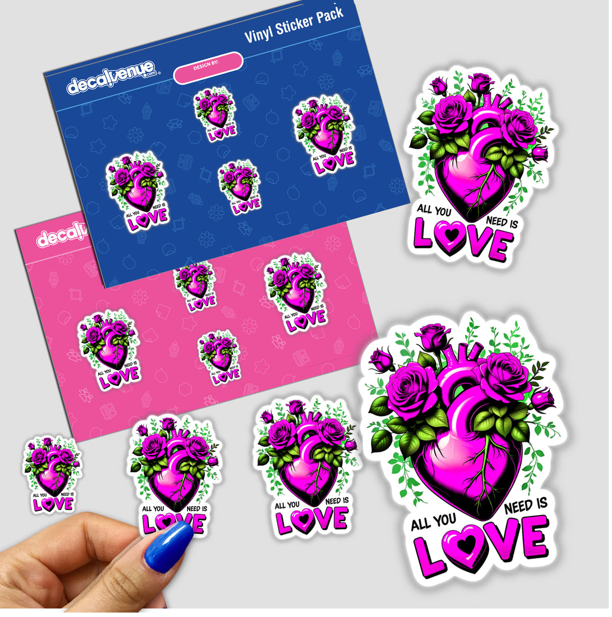 Hand holding 'All You Need Is Love' sticker pack featuring heart with flowers design, ideal as vinyl stickers or digital art, from Decal Venue's unique collection.