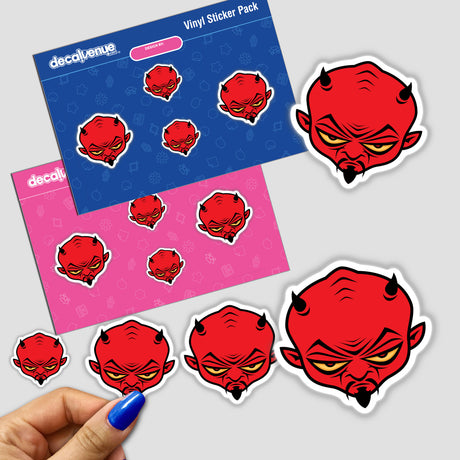 Devil Dude sticker pack, featuring multiple red devil faces with horns and distinct expressions, held in a hand. Available as a pack or individually, showcasing unique designs from Decal Venue.