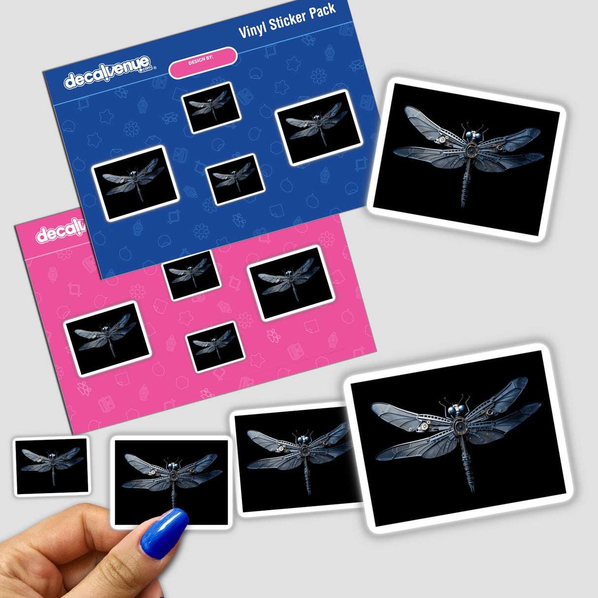 a hand holding a blue pen next to a pack of dragonfly stickers