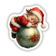 Baby Santa Sleeping on Christmas Ornament: A baby dressed in a Santa outfit sleeps peacefully atop a large, festive Christmas ornament, capturing a heartwarming holiday scene. Available as stickers or digital artwork.