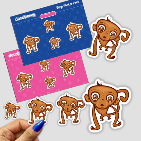 Cartoon Monkey Stickers: A hand holds a collection of stickers featuring cartoon monkeys with big eyes, reflecting Decal Venue's unique style. Perfect for adding playful charm to various surfaces.