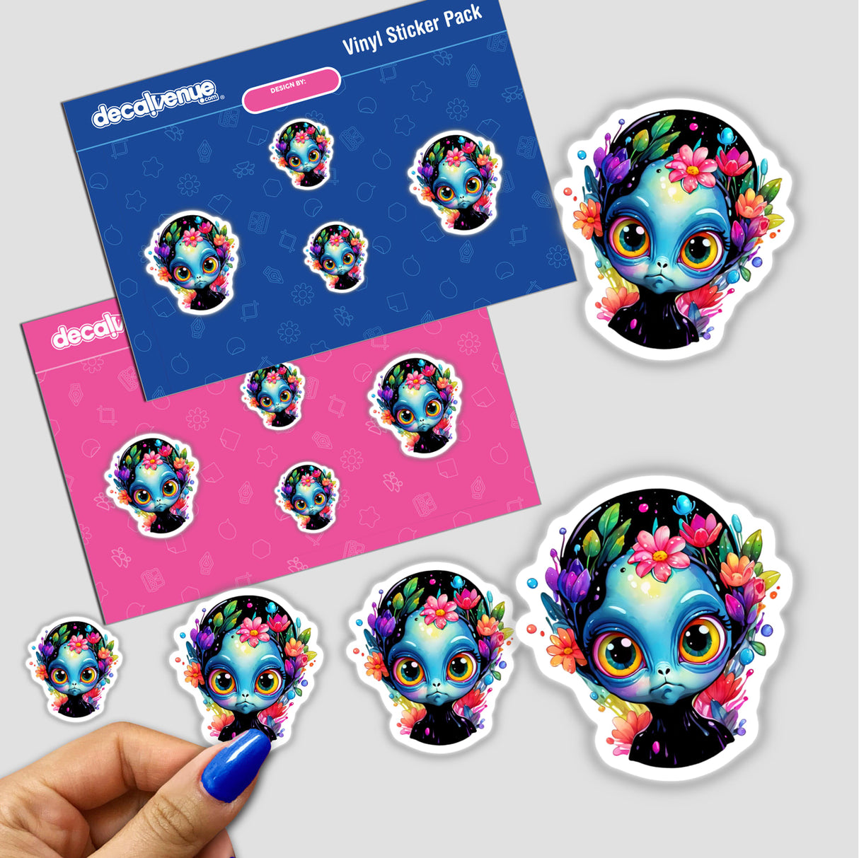 Grumpy Extraterrestrial: Floral Splash Alien Sticker featuring a cartoon alien surrounded by flowers, with a close-up of a person's finger holding one of the stickers.