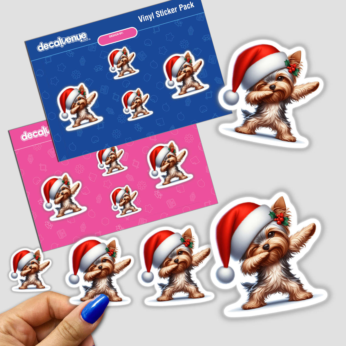 Dabbing Christmas Santa Yorkie Dog stickers featuring a cartoon Yorkie wearing a Santa hat. Close-up images show sticker details and a hand holding a blue pen. Available as Stickers or Digital Artwork.