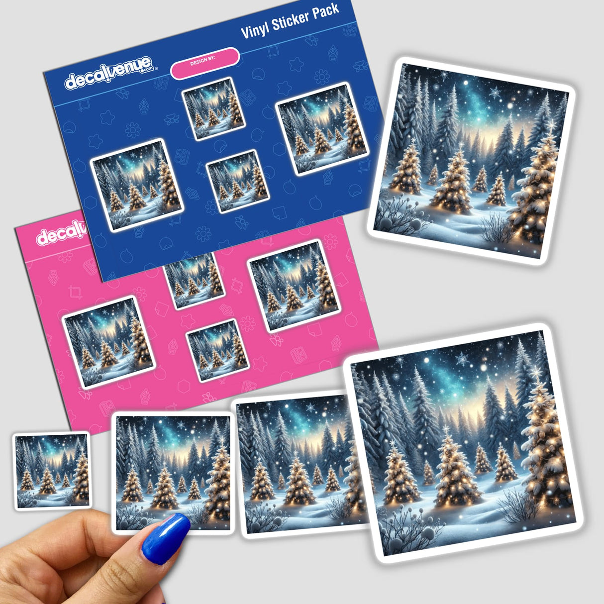 Hand holding a sticker pack titled Frosted Pines - A Snowy Forest with Decorated Trees, featuring images of snow-covered trees adorned with lights and festive decorations.