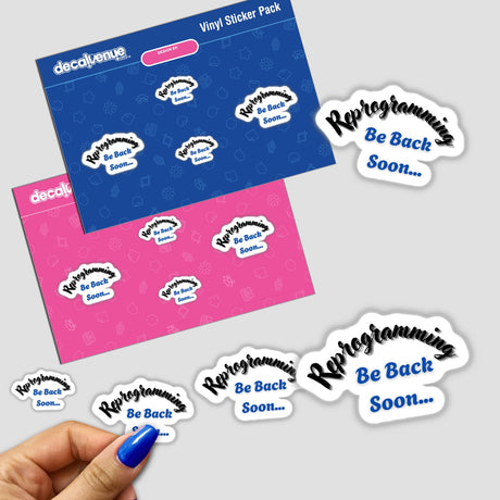 A hand holds Reprogram Yourself stickers, featuring bold white text on vibrant backgrounds, highlighting Decal Venue's unique design approach in stickers and digital art.