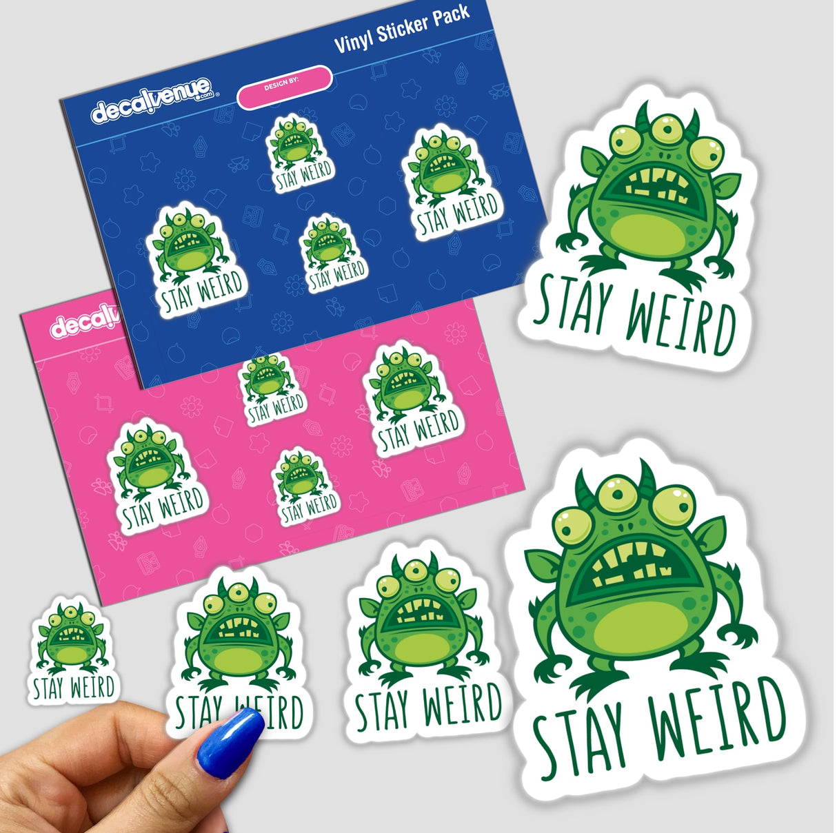 Stay Weird Alien Monster sticker pack featuring green three-eyed cartoon monsters with playful text. Includes close-up of blue nail polish showcasing sticker durability.